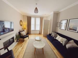 a living room with a blue couch and a table at Tynemouth Seaside 3 Bed House Close to Beach/Bars/Restaurants - Parking Space Included in Tynemouth