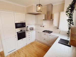 a kitchen with white cabinets and a stove top oven at Tynemouth Seaside 3 Bed House Close to Beach/Bars/Restaurants - Parking Space Included in Tynemouth