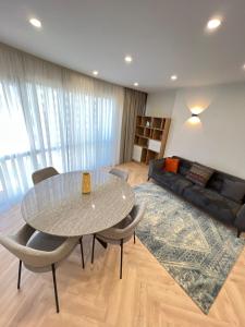 a living room with a table and chairs and a couch at Holiday Premium Apartments Batumi in Batumi