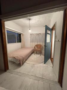 a bedroom with a bed and a chair in it at 経堂の小さな一棟貸wakusei in Tokyo