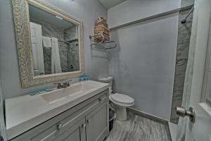 ein Badezimmer mit einem Waschbecken, einem WC und einem Spiegel in der Unterkunft Aqua View Motel in Panama City Beach