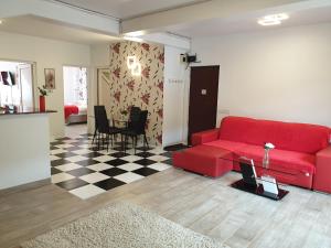 a living room with a red couch and a table at Sinaia Alex Apartments in Sinaia