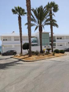 a parking lot with palm trees in front of a building at Remarkable 3-Bed Apartment in Carboneras in Almería
