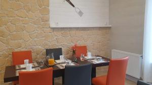 a dining room with a table and orange chairs at Domaine De l'Ourbise in Razimet