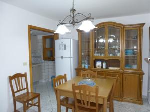cocina con mesa, sillas y nevera en Casa Vacanze Vincenzo e Rosanna, en Castro di Lecce