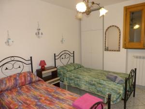 Habitación con 2 camas y espejo. en Casa Vacanze Vincenzo e Rosanna, en Castro di Lecce