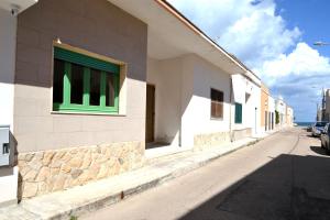 a building with a green window on a street at Luce holiday home with air conditioning for 5 guests in Roca Vecchia