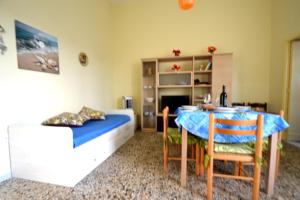 a living room with a bed and a table and chairs at Luce holiday home with air conditioning for 5 guests in Roca Vecchia