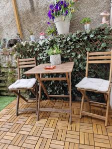 una mesa de madera y 2 sillas en el patio en Tynant House- Modern 3 bed house- City centre and FREE parking, en Cardiff