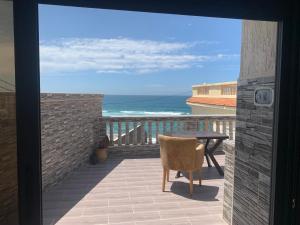 uma varanda com uma mesa e vista para o oceano em El mar beach 2 em Moulay Bousselham