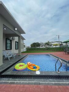 ein Schwimmbad mit einem Teddybär auf einem Floß in der Unterkunft LAMAN KASEH Homestay Bukit Katil 4bedroom with Swimming Pool in Ayer Keroh