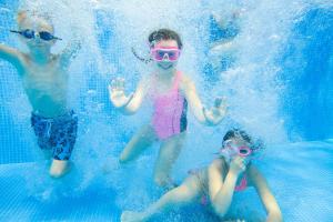 tres niños están jugando en una piscina en Beautiful 8 Berth Lodge For Hire At Kessingland Beach In Suffolk Ref 90012td en Benacre