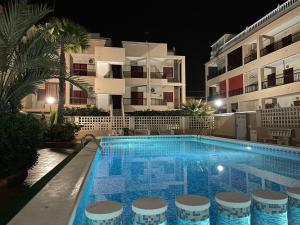 ein Schwimmbad vor einem Gebäude in der Nacht in der Unterkunft Apartmento HANA con terraza - PLAYA LA MATA in La Mata