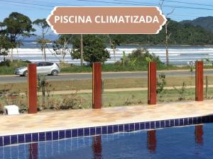 ein Schild, das Piscina Chitaraka in der Nähe eines Schwimmbads liest in der Unterkunft Pousada Vila da Lagoa in Ubatuba