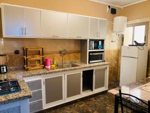a kitchen with white cabinets and a sink and a refrigerator at Guest house ma in Midelt