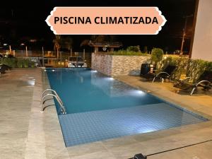 ein Schwimmbad in der Nacht mit einem Schild, das Pistina Climedia liest in der Unterkunft Apartamentos para locação em Ubatuba in Ubatuba