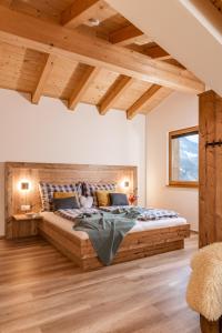 Un dormitorio con una gran cama de madera en una habitación con techos de madera. en Piekvier lodge, en Schladming