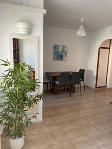 ein Esszimmer mit einem Tisch und einer Topfpflanze in der Unterkunft Apartmento HANA con terraza - PLAYA LA MATA in La Mata