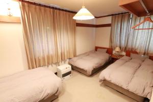 um quarto com 2 camas individuais e uma janela em Larix Tateshina Villa - Vacation STAY 86531v em Chino