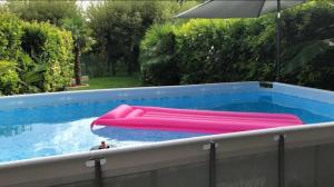 einen Pool mit rosa Schlauchbooten und einem Regenschirm in der Unterkunft L'Echo - ST / Soitec / Innovalée in Saint-Ismier