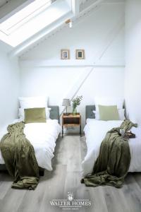 two beds in a room with white walls at Fachwerkcharme: Wohnen in großer Maisonettwohnung in Villingen-Schwenningen