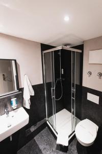 a bathroom with a shower and a toilet and a sink at City Hotel Fellbach 24H CHECK-IN in Fellbach