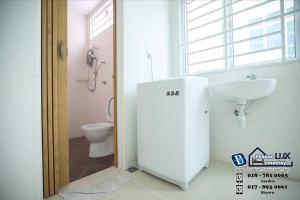 Baño blanco con lavabo y aseo en Balik Pulau 6BR Comfort Home Villa, en Balik Pulau