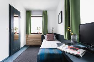um quarto com uma cama e uma secretária com um computador em City Hotel Fellbach 24H CHECK-IN em Fellbach