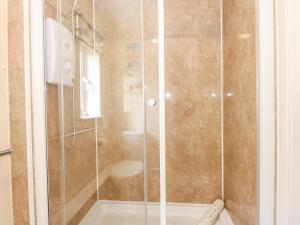 a shower with a glass door in a bathroom at 15 The Dell in Norwich