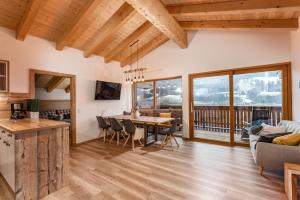 a kitchen and living room with a table and chairs at Piekvier lodge in Schladming