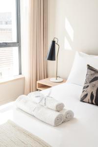 een wit bed met twee handdoeken erop bij Casa on Kei Apple by Totalstay in Kaapstad