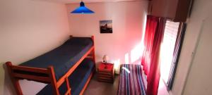 - une chambre avec des lits superposés et une fenêtre dans l'établissement Destino San Juan Hostel, à San Juan