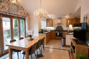a kitchen with a table and a clock on the wall at Spacious 4 Bedroom detached house with parking for 3 cars in Victoria
