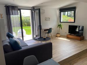 uma sala de estar com um sofá e uma televisão de ecrã plano em Logement indépendant dans villa avec jardin em Ventabren
