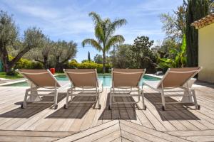 three chairs sitting on a deck next to a pool at Villa Casalive in Solliès-Pont