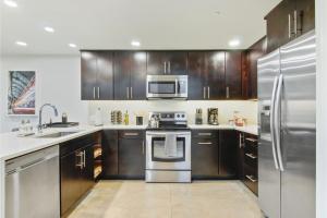 a kitchen with wooden cabinets and stainless steel appliances at Roami at Motorworks in New Orleans