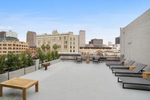 a rooftop patio with benches and a city skyline at Roami at Motorworks in New Orleans