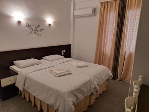 a bedroom with a bed with two towels on it at Galanopoulos Hotel in Loutraki