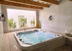 a large bath tub in a room with a window at Alfons Hotel in Ciutadella