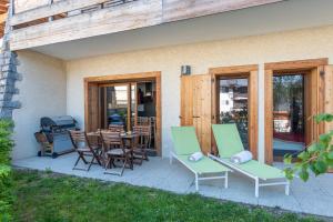 patio z krzesłami, stołem i sprzętem do grillowania w obiekcie Apartment Les Alpages w mieście Les Gets