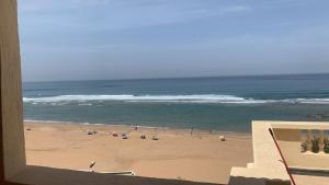 a view of a beach with a group of people at El mar beach 2 in Moulay Bousselham