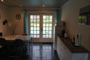 a kitchen with a table and a refrigerator at Guesthouse Rijsbergen_Zundert in Zundert