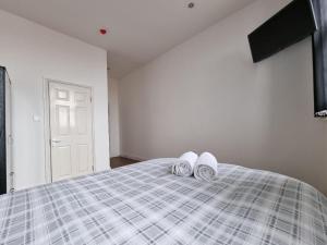 um quarto com uma cama com dois pares de chinelos brancos em Portside Liverpool em Liverpool
