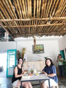 Dos mujeres sentadas en una mesa en un restaurante en A-Manta Homestay en Labuan Bajo