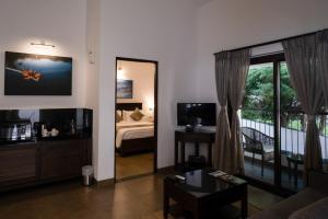 Sala de estar con cama y espejo en Dvara Luxury Resort Kodaikanal, en Kodaikanal