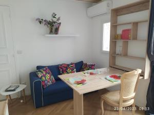 een woonkamer met een blauwe bank en een tafel bij la maison de josy in Aix-en-Provence
