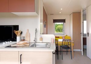 a small kitchen with a sink and a table at Frantheor Saint-Raphael 4 étoiles in Saint-Raphaël