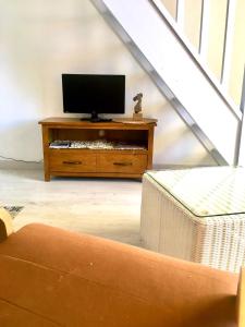 un salon avec une télévision sur un support en bois dans l'établissement Bella vista ,accès direct plage, front de mer, vue mer panoramique, au Barcarès