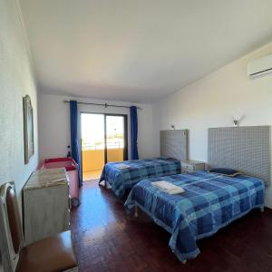 Habitación de hotel con 2 camas y ventana en Villa Paraiso - 4 Bedrooms and pool, en Albufeira