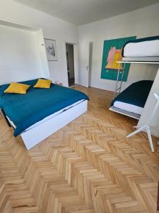 a bedroom with a bed and a wooden floor at The Green Door Apartment in Postojna